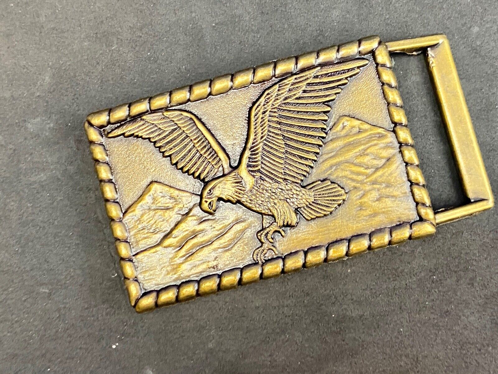Vintage flying, hunting, fishing American eagle belt buckle with western boarder