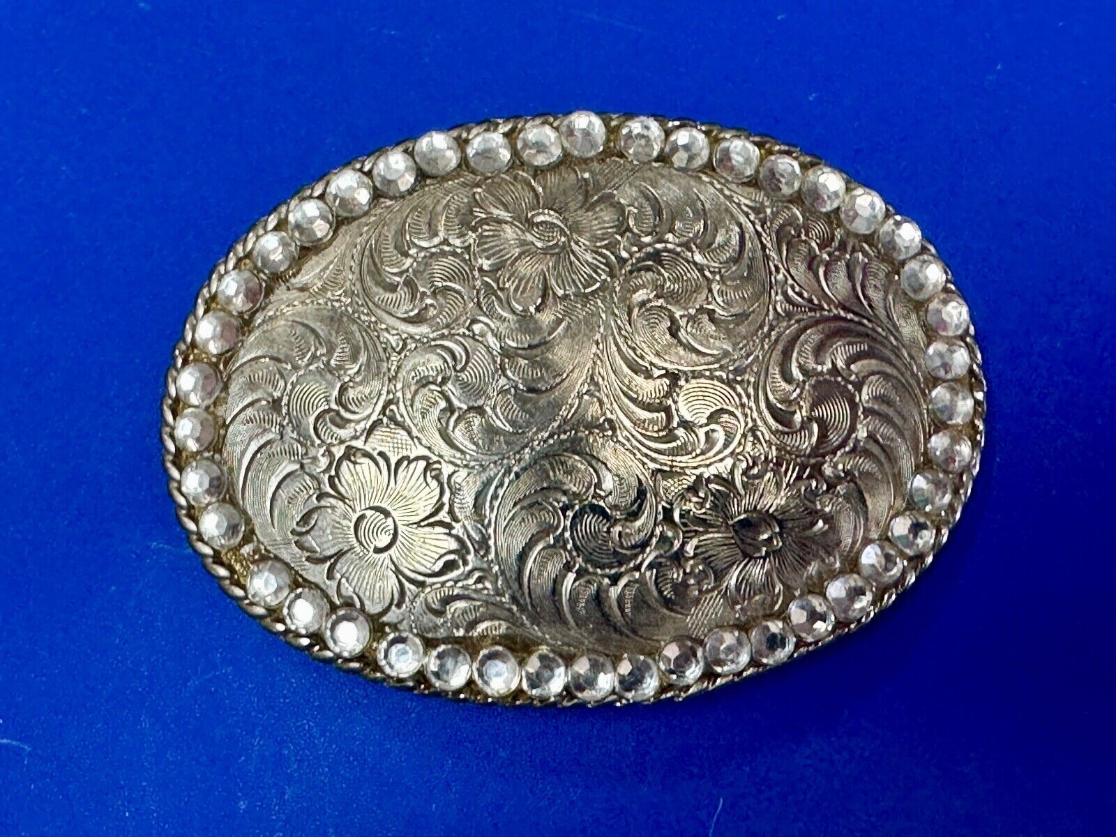 vintage 1996 western flower swirl oval belt buckle with rhinestone boarder