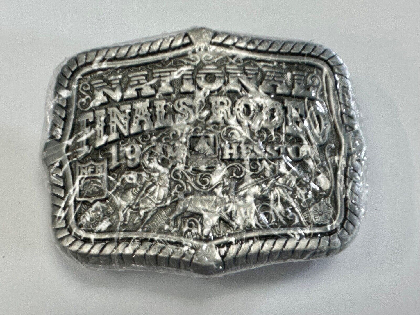 1999 Youth Sized Hesston National Finals Rodeo 2000 series belt buckle in wrap